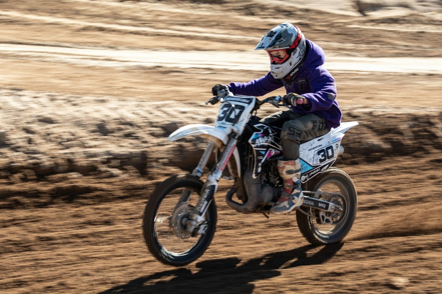 Pilote de moto tout-terrain sur une piste de sable
